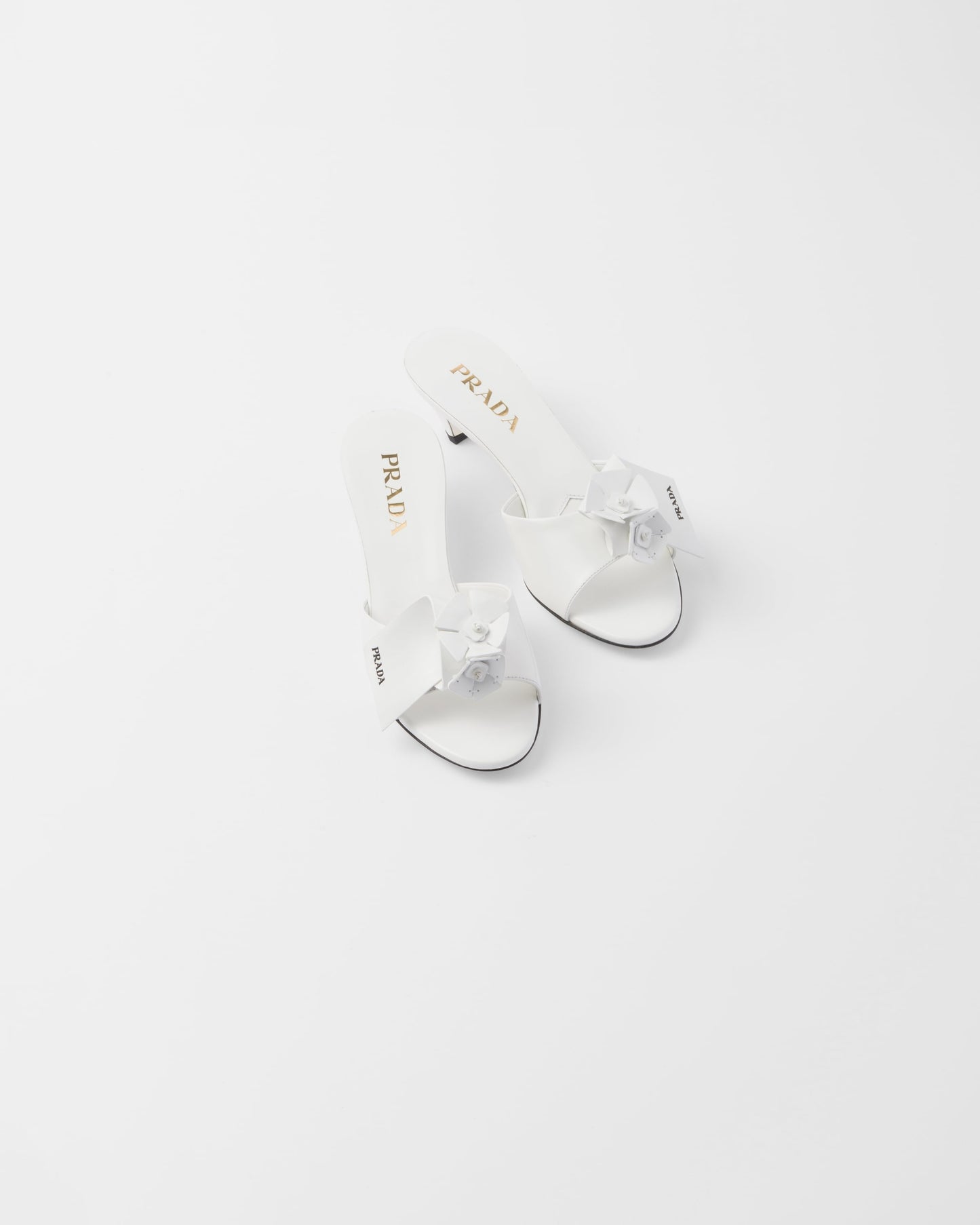 Bianco patent leather heeled mules with prada logo