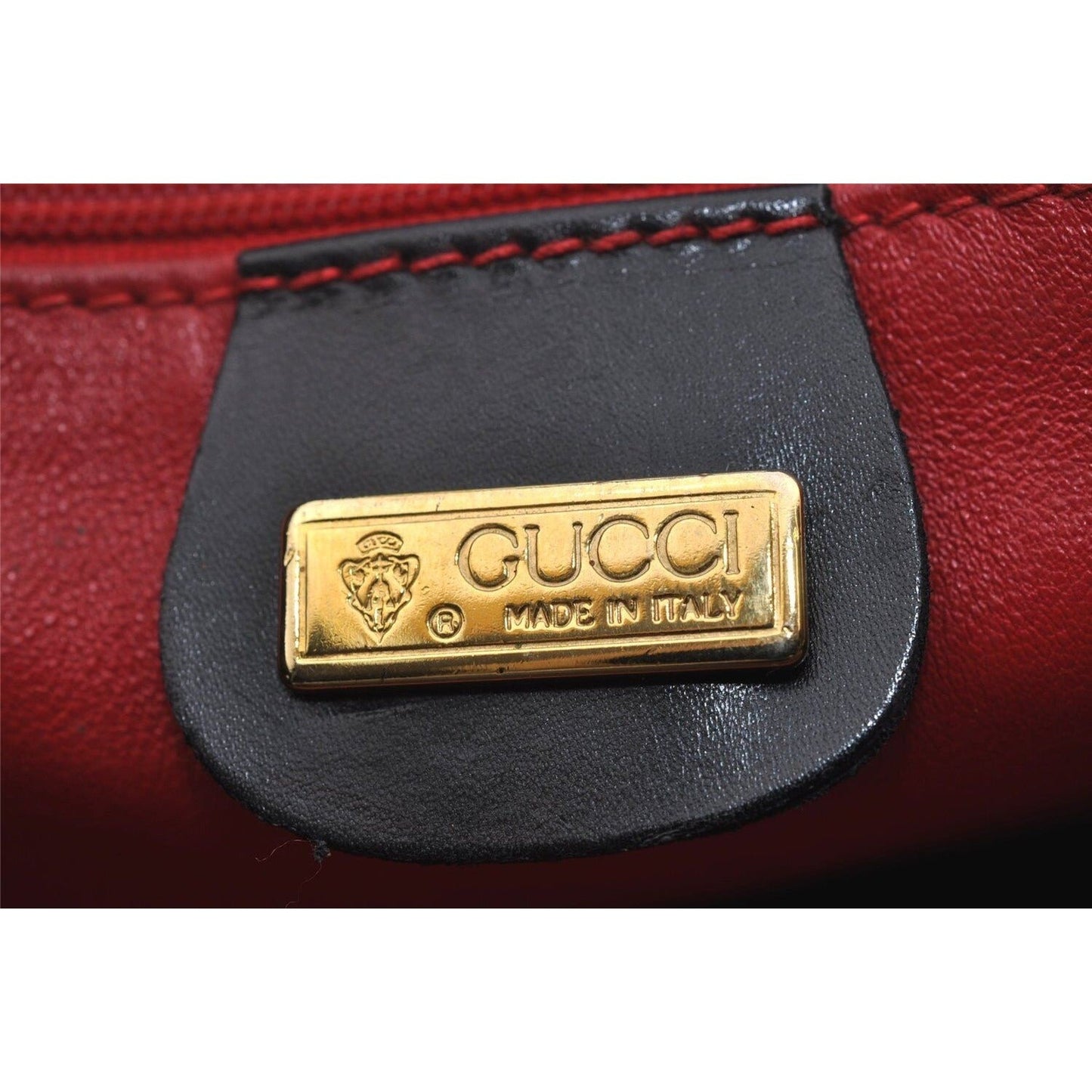 Mod Gucci, black leather shoulder bag with two longer straps, two exterior pockets, a hinged opening, and a gold and bamboo accent clasp